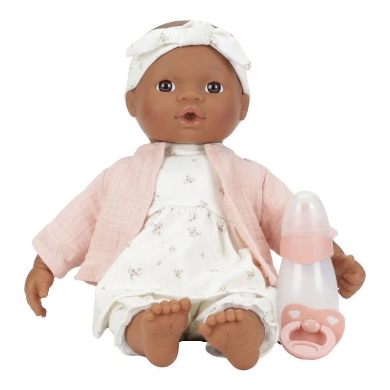 Baby doll with pink outfit and bottle on a white background