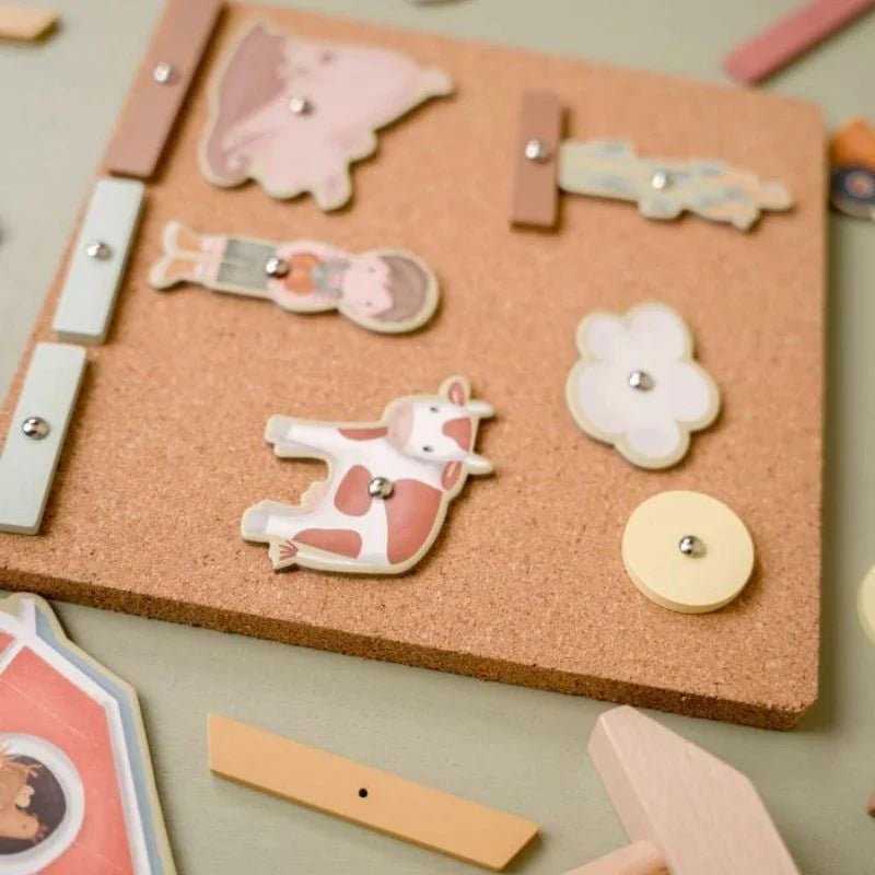 Cork board with animal-shaped pins on a light green background