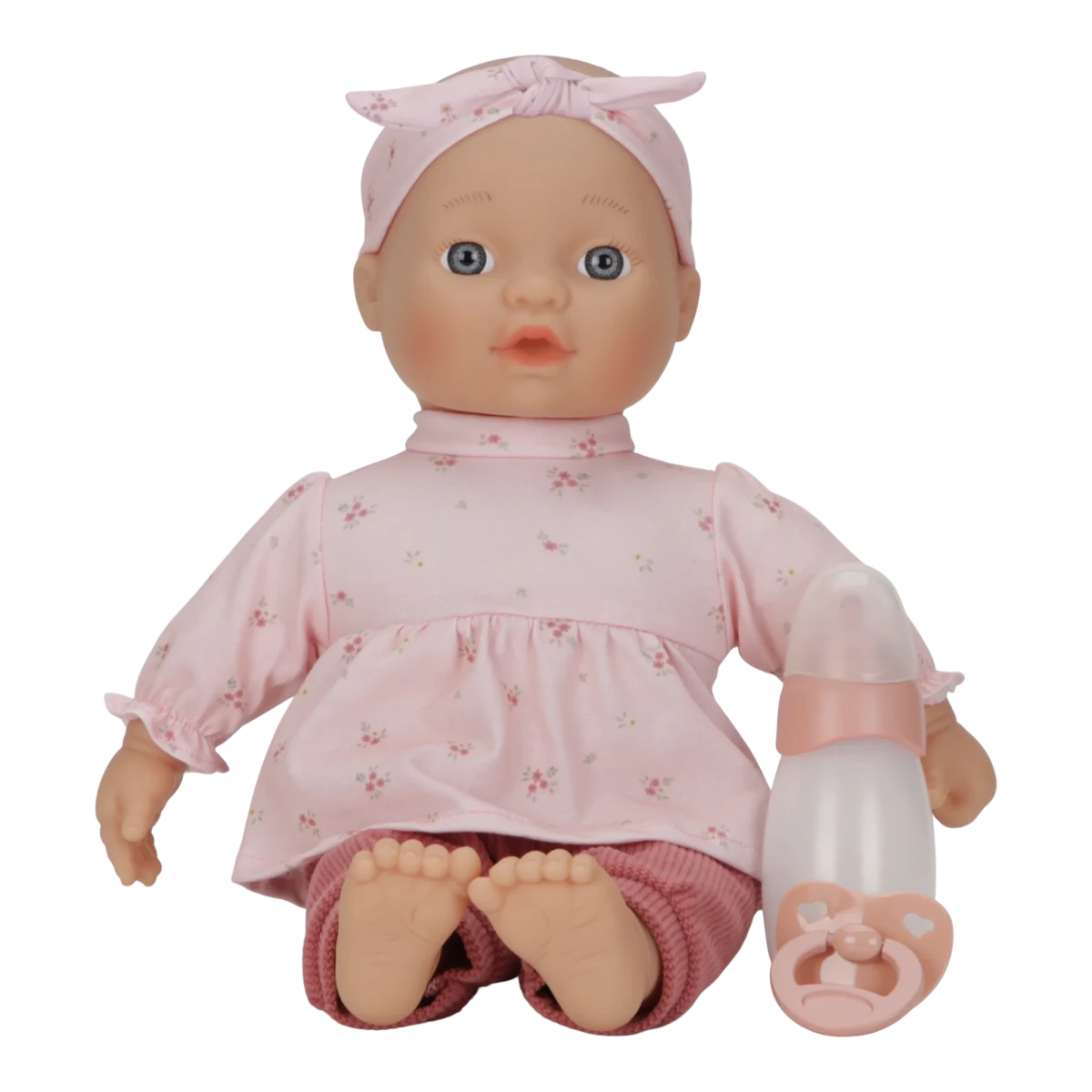 Baby doll in pink outfit with a pacifier on a white background
